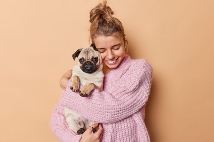 犬を抱きかかえる女性