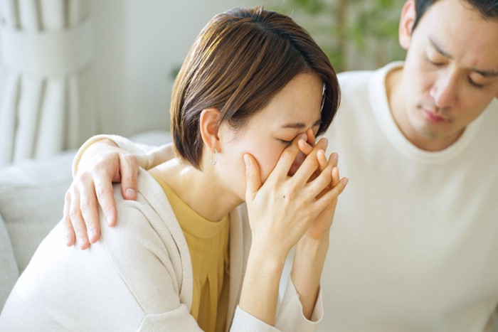 悲しむ女性を慰める男性