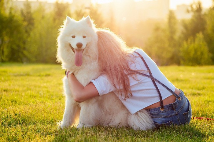 背中向けた女性と笑顔の犬