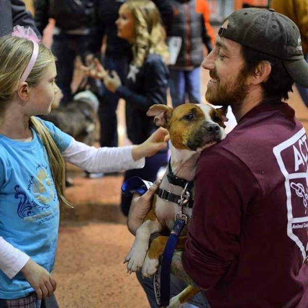 犬に触れる少女と笑顔の男性