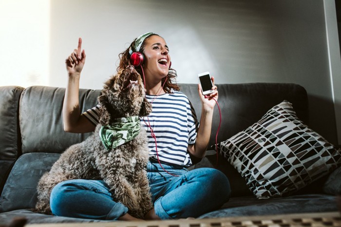 一緒に音楽を楽しむ女性と犬