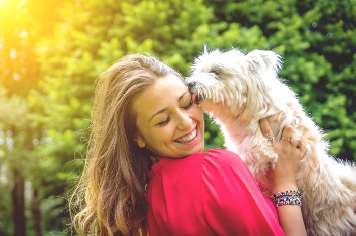 女性の顔を舐める犬