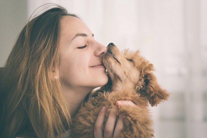 スキンシップをとる女性と犬