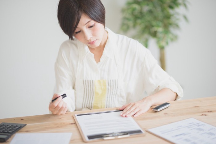 書類に判を押す女性
