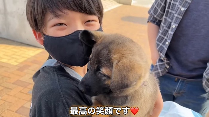 子犬を抱っこして笑顔の男の子