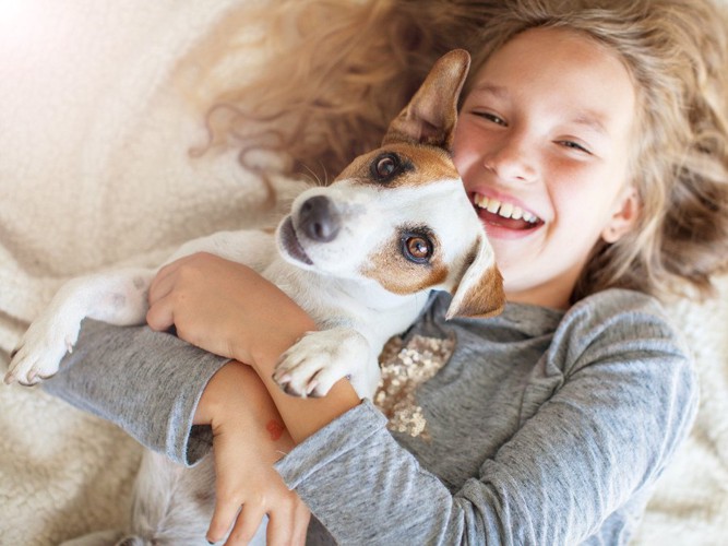 子どもに抱えられている犬