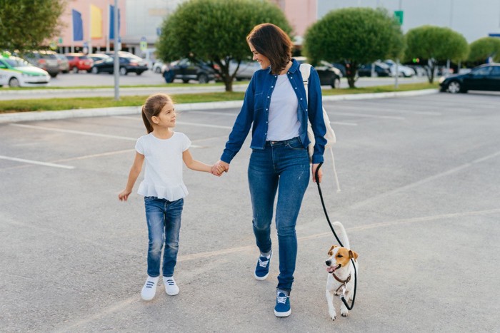 犬を駐車場で歩かせる親子