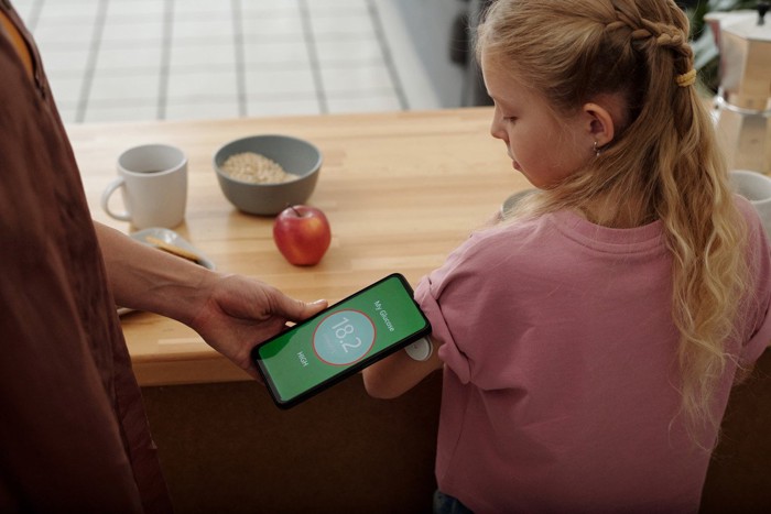 糖尿病の子どもの血糖値をチェックする母親