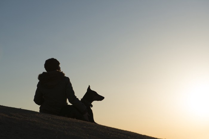 飼い主と犬のシルエット