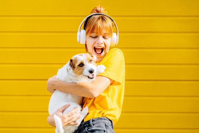 ヘッドホンを付けた女性と犬