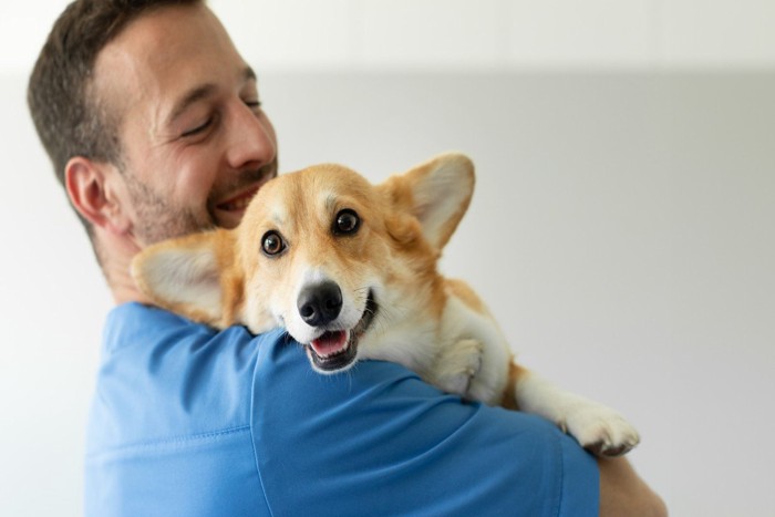 男性にハグされている犬