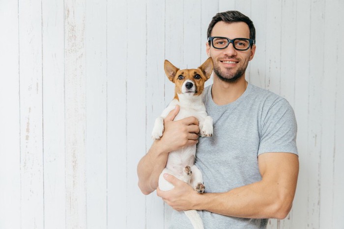 犬を抱く男性