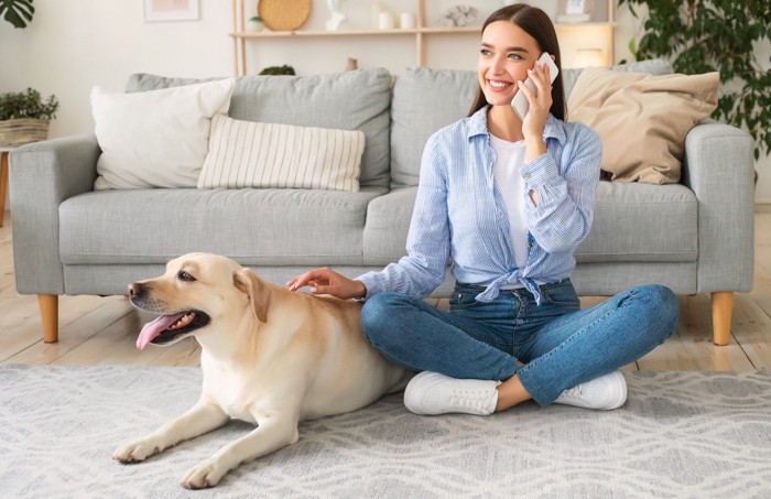 電話する女性と大型犬