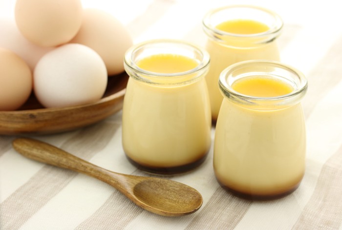 瓶詰めされたプリンと原材料の卵