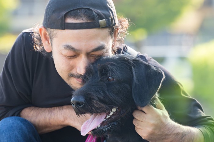 犬を抱き寄せる男性