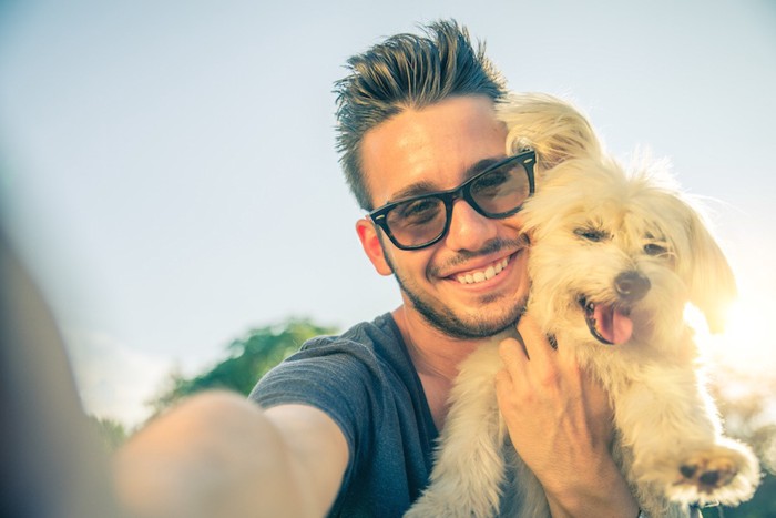 犬と自撮りする男性