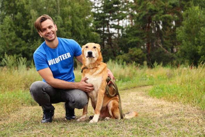 保護施設のボランティアの男性と犬