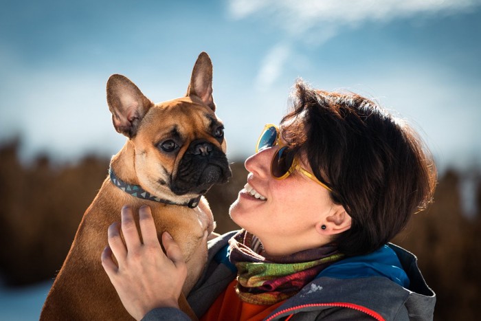 アイコンタクトする女性と嫌がる犬