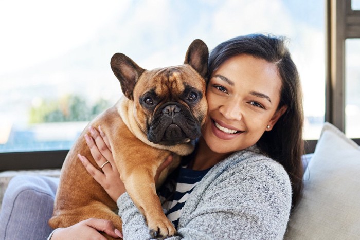 顔を近づける女性と嫌そうな犬