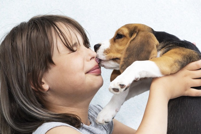 女性の顔を舐める犬