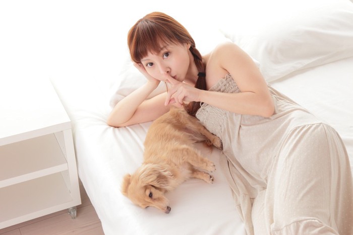 犬と添い寝している女性