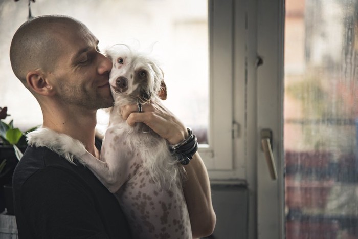 笑顔で犬にキスする男性