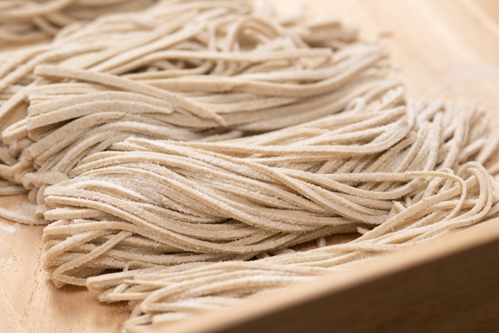 木箱の中に並べられた生の手打ち蕎麦