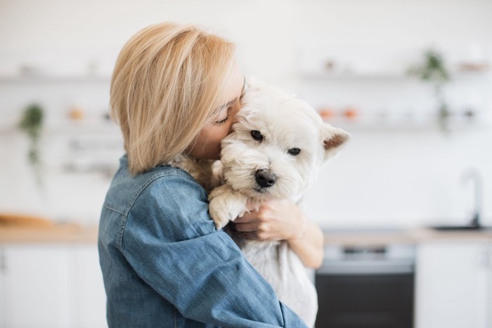白い犬を抱きしめる