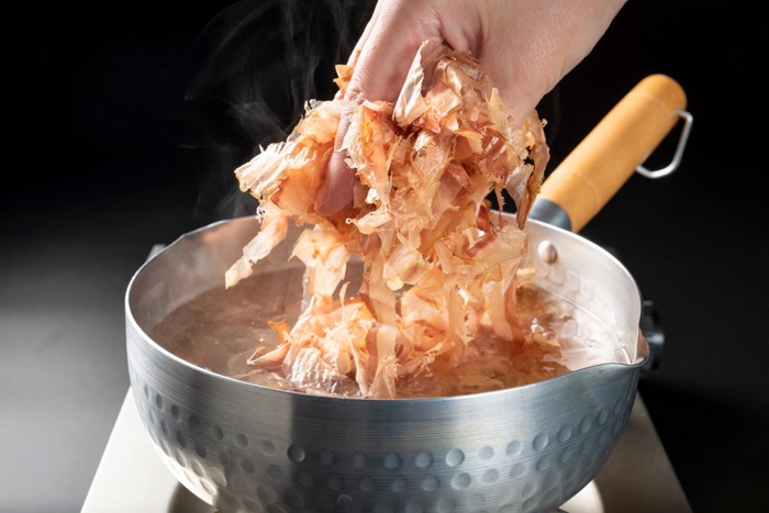 鍋にかつおぶしを入れて出汁をとろうとしている様子