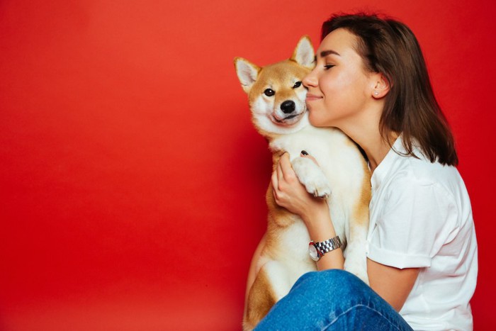 柴犬を抱きしめてキスをする女性