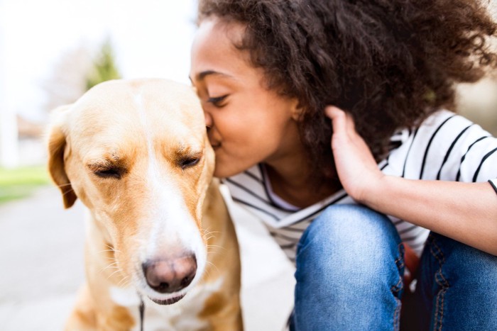 キスする女性と困った顔の犬