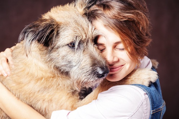 大きな犬とハグをする女性