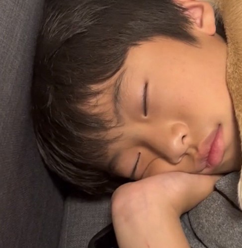 手を枕に眠る男の子
