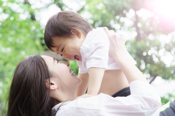 笑顔で子供を抱き上げるお母さん