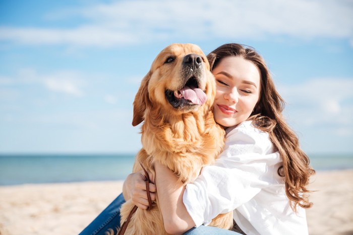 女性と犬と海