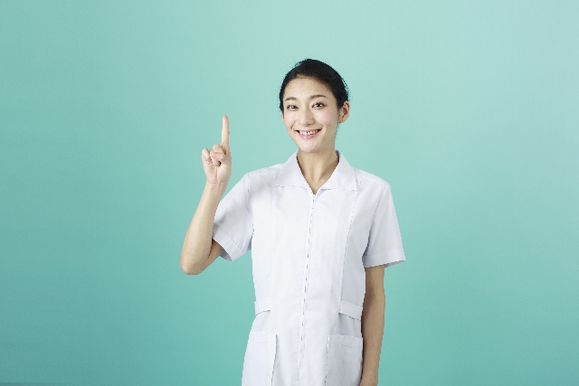 看護師 笑顔 ナース服 人差し指を上げている