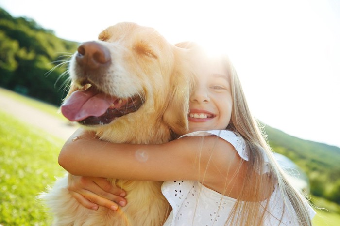 子供にハグされている犬