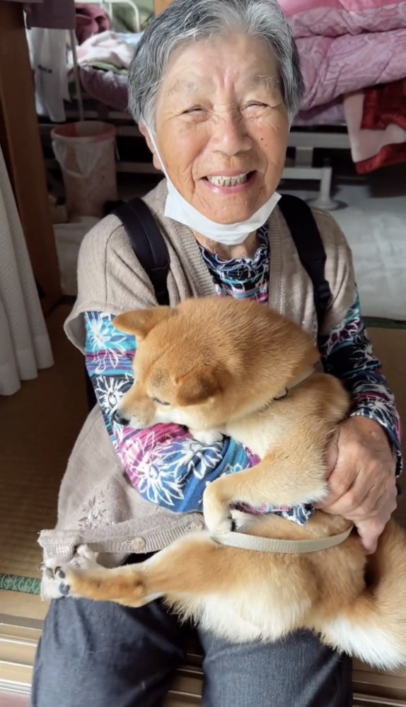 犬を抱えて笑う人