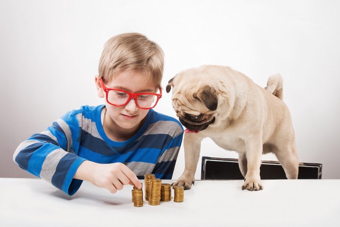 コインを数える子供と犬