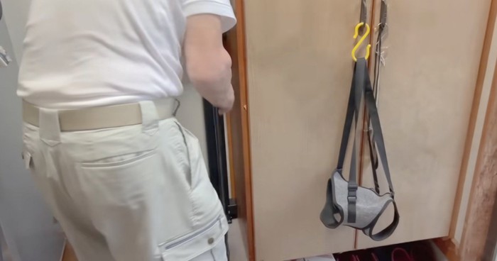 玄関に取り付けたロールカーテンをひっぱるおじいちゃん