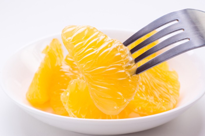 はっさくの果肉をフォークにさして持ち上げている様子