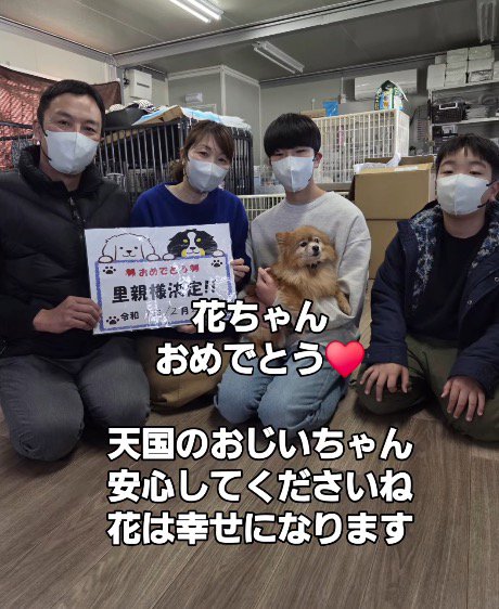 犬を囲んで記念撮影をする家族たち