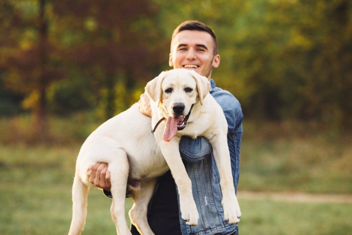 犬を抱っこする男性