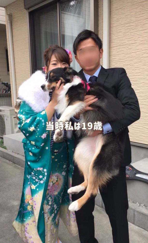 犬を抱き上げる成人式の女性