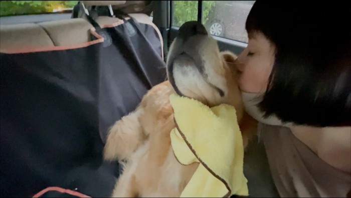 飼い主にキスされる犬