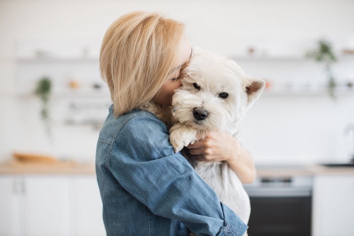 白い犬を抱きしめる