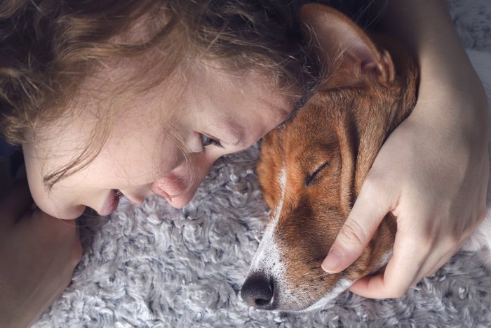 おでこをくっつける犬と女性