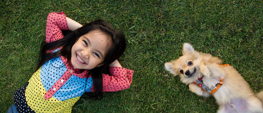 並んで仰向けに寝る女の子と犬