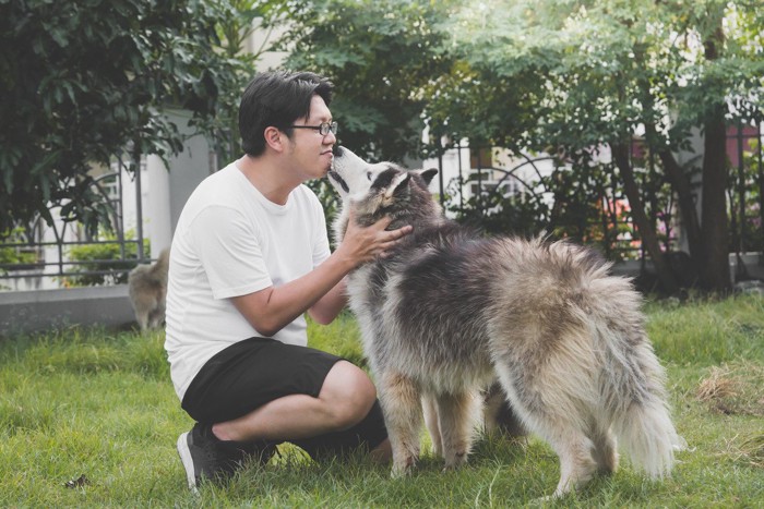 人に口元を寄せる犬