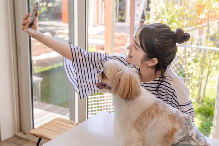 自撮りする女性と犬